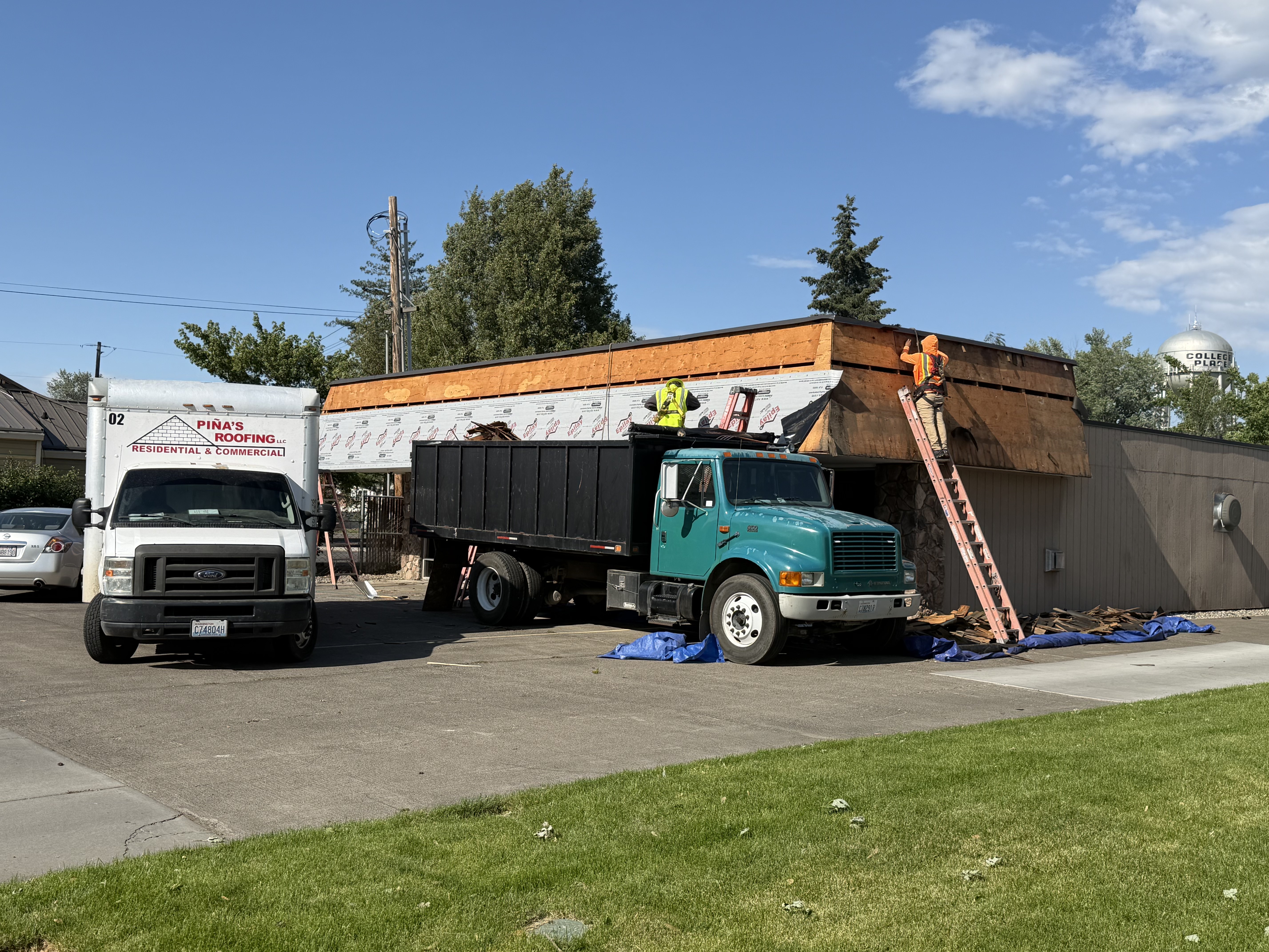 Roofing crew installing new decking and underlayment on the commercial office