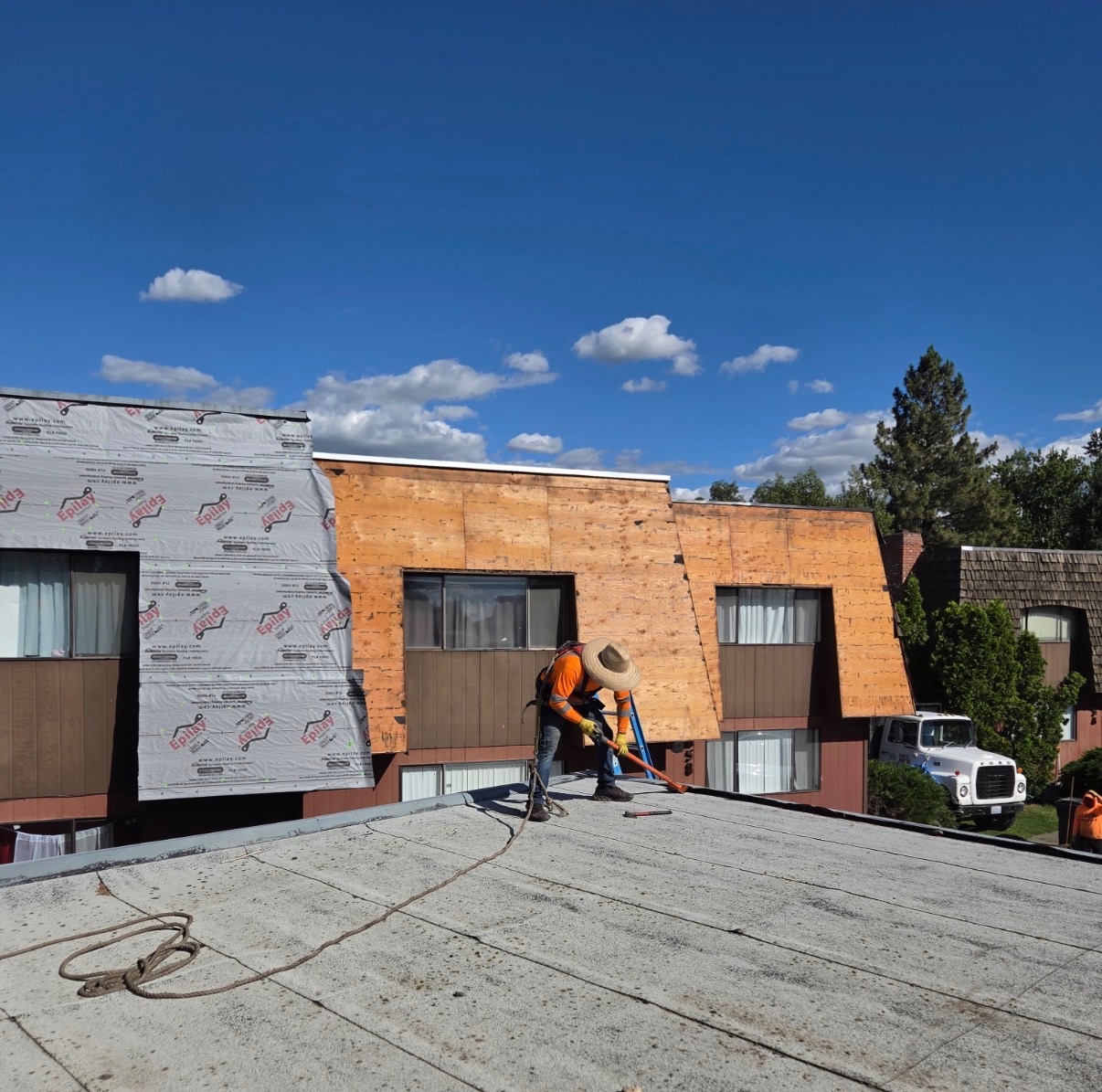 Piña's crew member working on a multi-family building roof