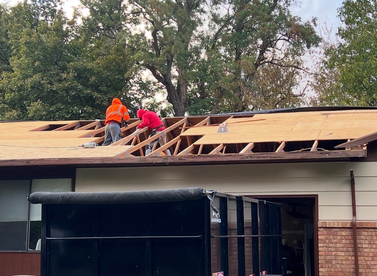 Crew installing new roof decking and framing on a residential re-roof
